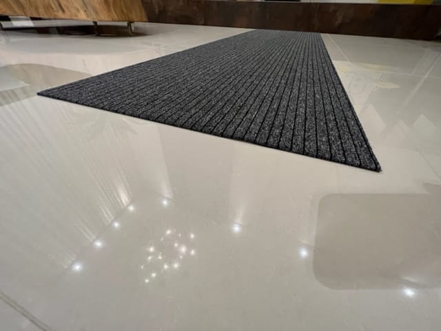 Detalhe que mostra o perfil do tapete starmix absorvente que se incorpora ao piso e evita o risco de tropeços