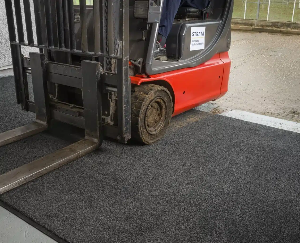 empilhadeira passando sobre tapete absorvente para secagem e limpeza dos pneus