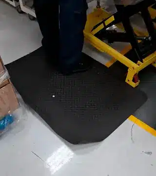 Canto do tapete adaptado dobrado e levantando do piso